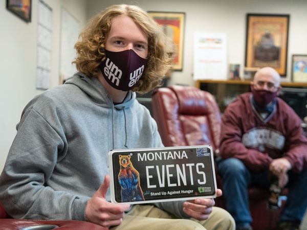 UM student Jack Person holds a license plate that says "�Թ��� Events." 