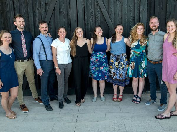 An image of 10 people who are dressed up and smiling 