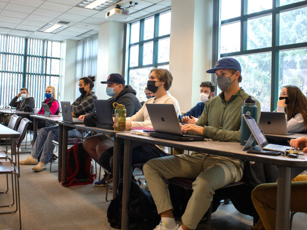 Masked UM College of Business students sit in a UM classroom