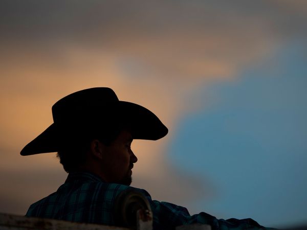 A silhouette of a cowboy at sunset.