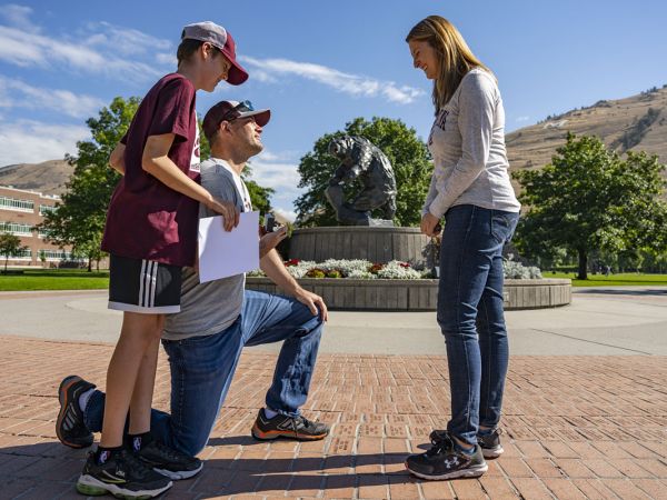 Andrew Pitsch proposes to Linsey Trenary on the University of Montana Oval Sept. 24 while her son, Landon, looks on. 