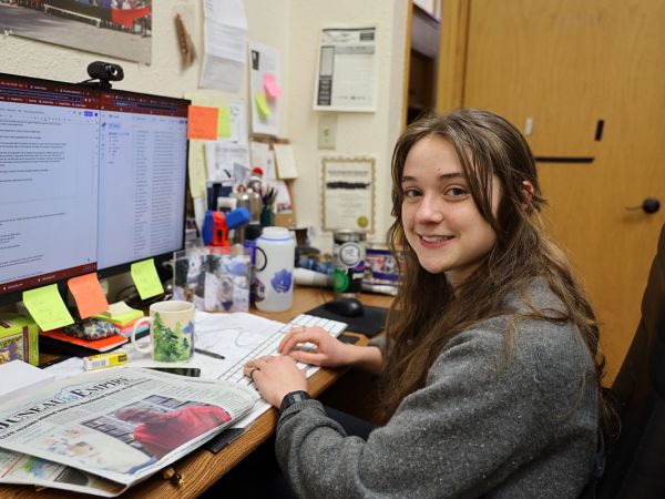 UM alumna Clarise Larson is shown working at her desk at the Juneau Empire newspaper.