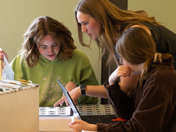 Photo of students looking at photo slide sleeves