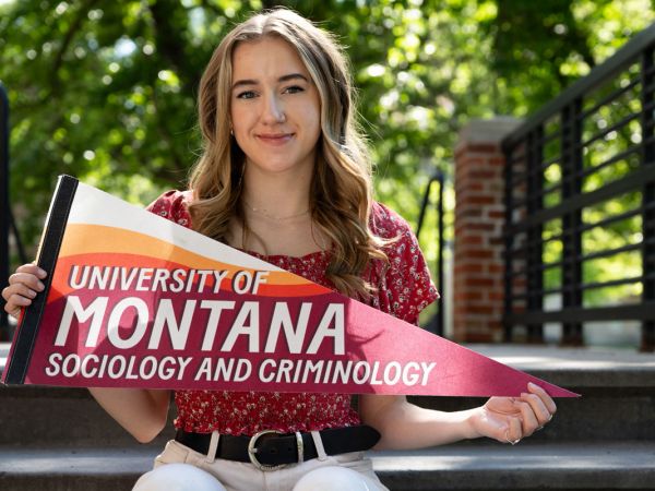 Tia Zaremski holds up a banner for UM Sociology and Criminology.