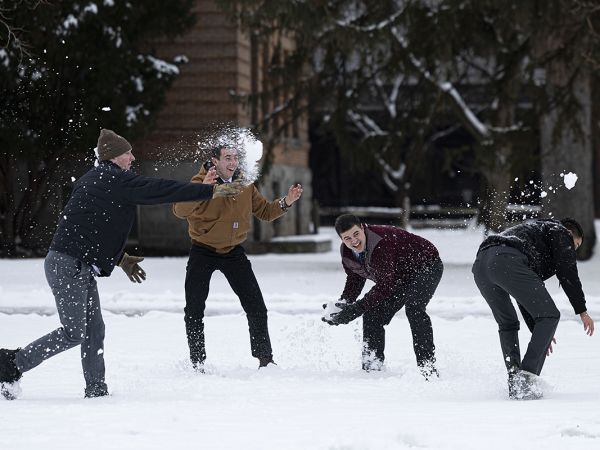 Male students have a snowball fight at UM.