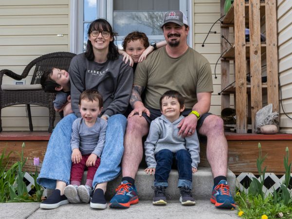 Keely McFarren sits on his front porch in Missoula with his wife and their four children.
