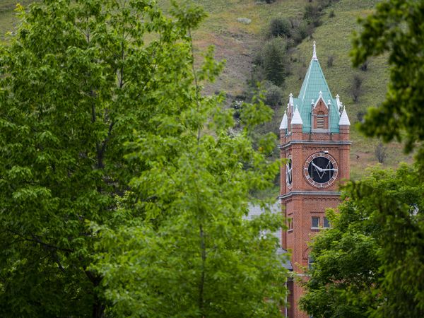 The Main Hall clock tower is visible between green trees.