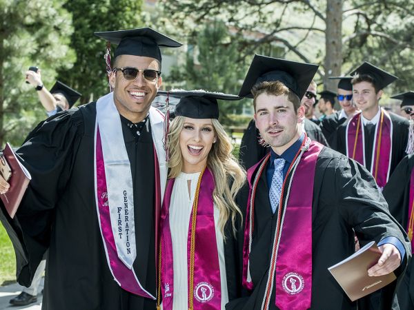A picture of three happy students at UM Commencement.