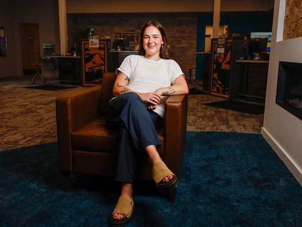 A picture of Roni Hecker sitting in chair with a confident pose.