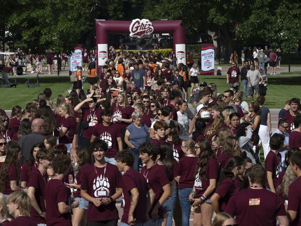A crowd of students, and some of their parents, enjoy the Big Sky Experience on the Oval at UM.