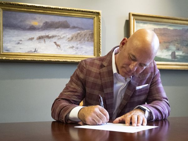 University of Montana President Jeremiah Shinn signs a document declaring every Friday in Griz Nation as "Griz Fridays."