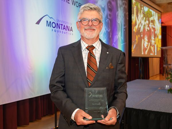Tim O’Leary holds the Neil S. Bucklew Presidential Service Award.