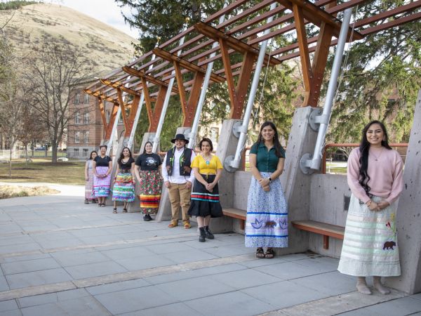 Student members of Kyiyo lean against the Payne Family Native American Center 