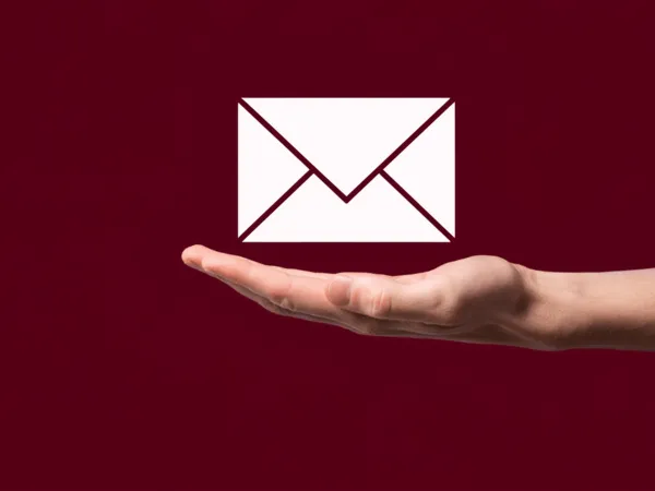 An extended hand with a floating email icon above it