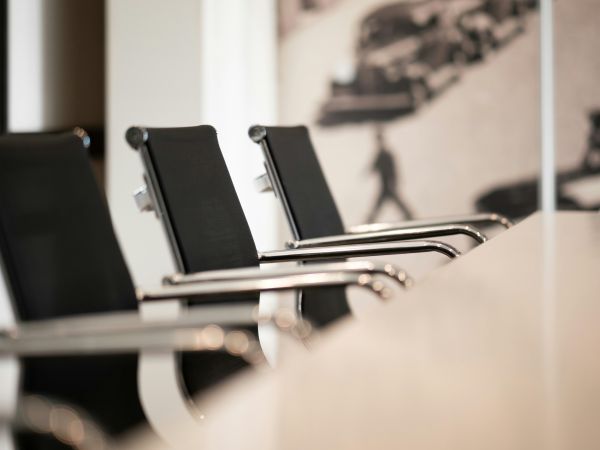 row of office chairs sitting on one side of a table