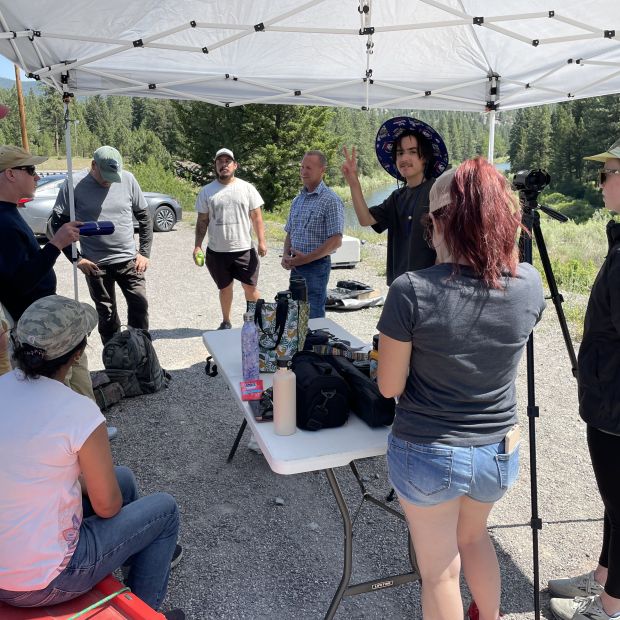 people gathered around a table under a tent