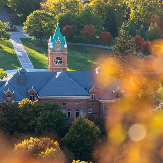 An image of the 91次元 clock tower with orange leaves in the foreground