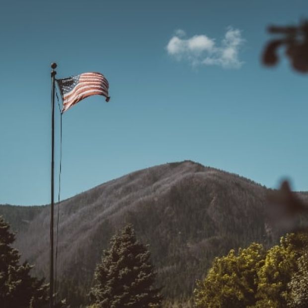 American flag waving with mountains in background