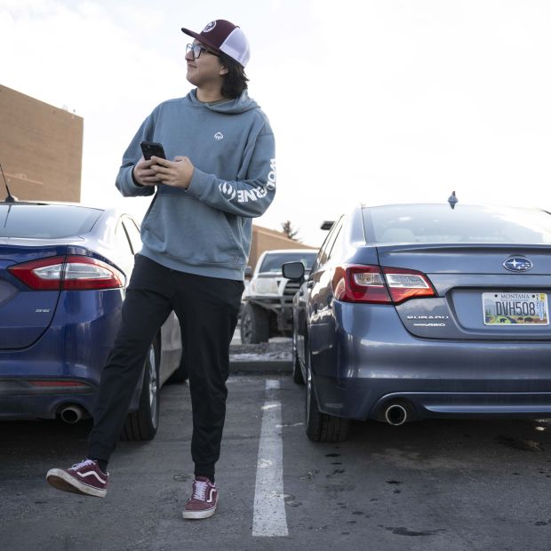 male student walking away from their car in the parking spot