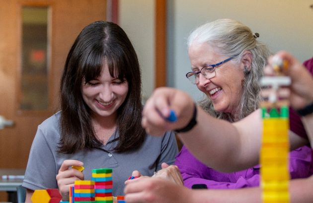 A student and faculty member using math manipulatives