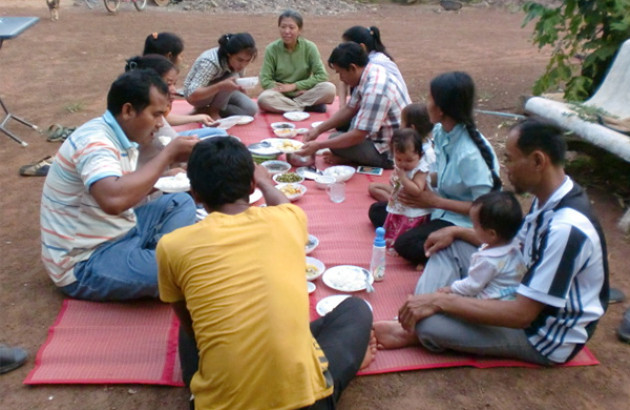 outdoor picnic with 10 people sitting in a circle on a blanket