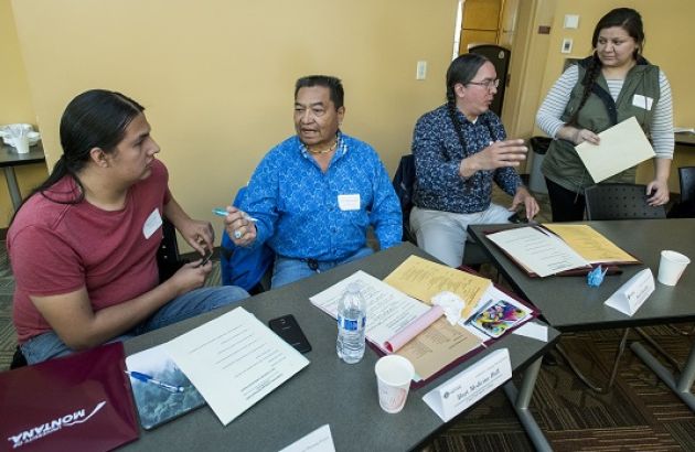 several people sit at a table in discussion