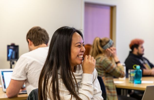 College of Education student laughs while chatting with classmates.