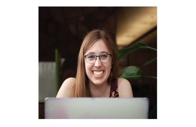 Girl smiling up from laptop