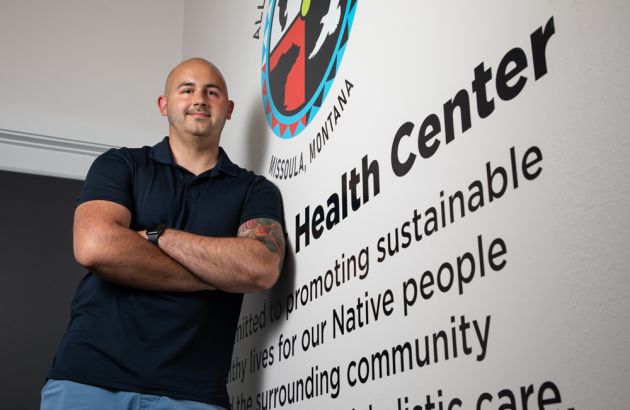 UM student Jacob Horton leans against a mural in at the All Nations Health Center