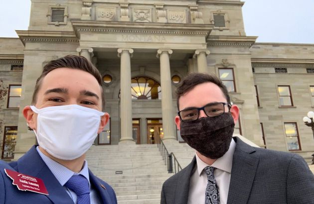 Two UM students wearing masks stand outside the Montana capital building