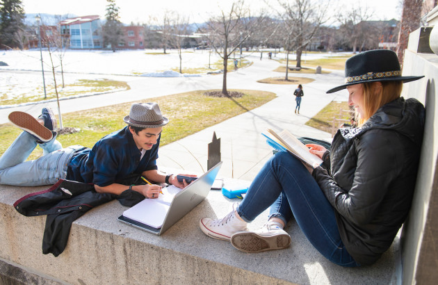 Two students study in the sunshine on the steps of Rankin