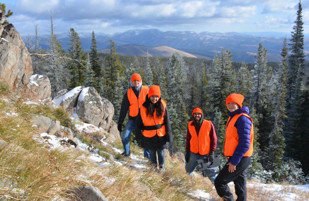 A group of students installs monitoring equipment in the mountains