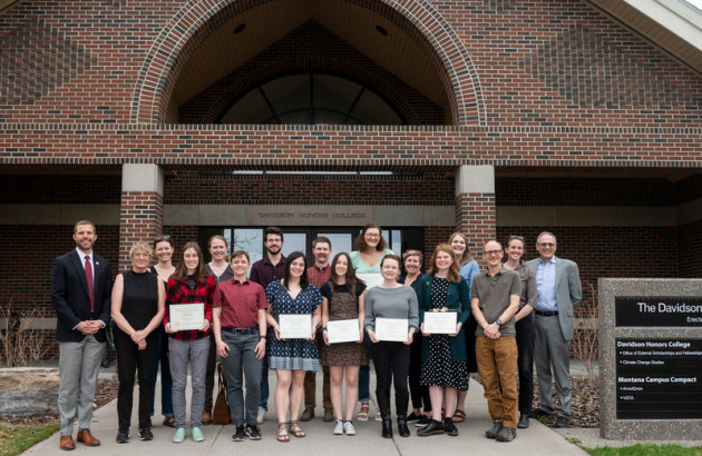 A group of students and faculty stand in front of the DHC