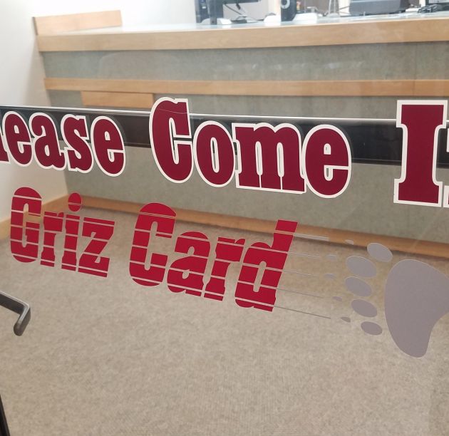 Front door of Griz Card Center saying "Please Come In"
