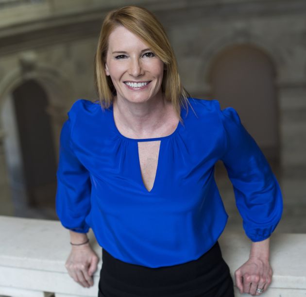 Woman in blue shirt stands in marble building