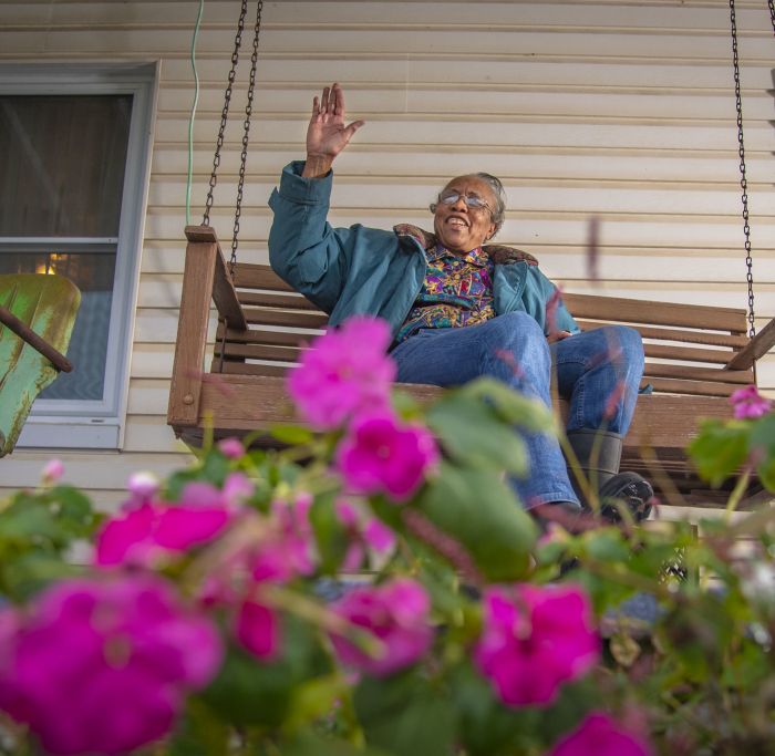 Woman waving on a porch swing