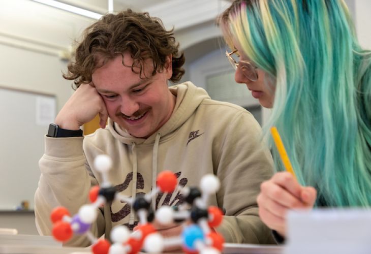 students studying a plastic model of a molecule