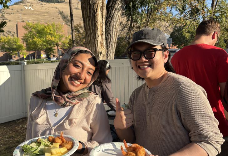 two students holding plates of food