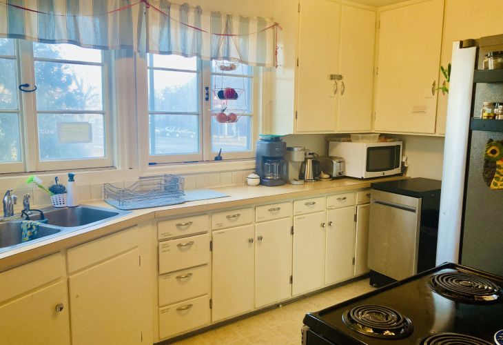 Kitchen with large cupboards, a fridge, stove, oven and sink