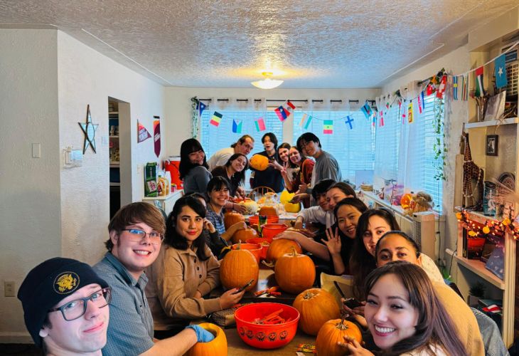 Students at a large table carving pumpkins