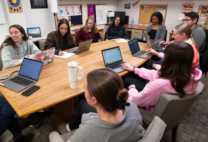 CRESP lab members sitting around a table with laptops open