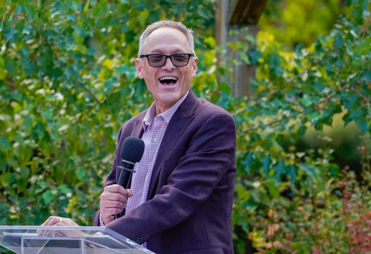 Dean Nichols standing at podium on the DHC patio