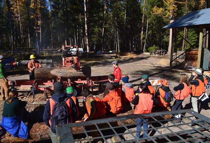 Students watch a demonstration of the sawmill at Lubrecht with professor of wood science Ed Burke