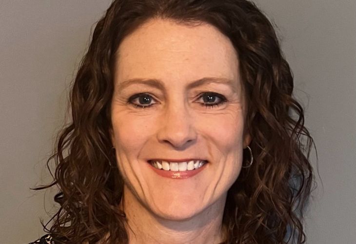 headshot of laurie slovarp, a woman with shoulder-length brown curly hair