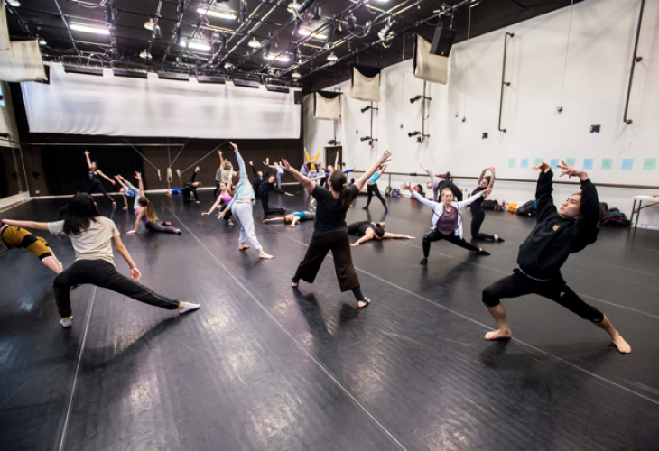 Dance technique class performing expressively with the instructor in the middle