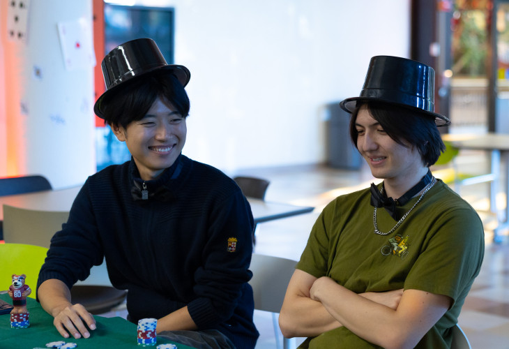 Two men smiling at each other while playing casino games