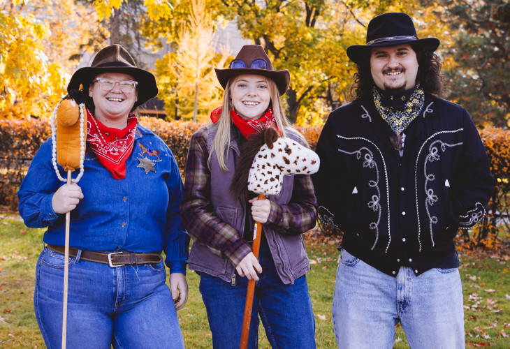 A group of three people dressed up as cowboys 