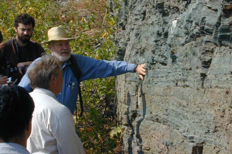 Don touches a rock face while three others look on