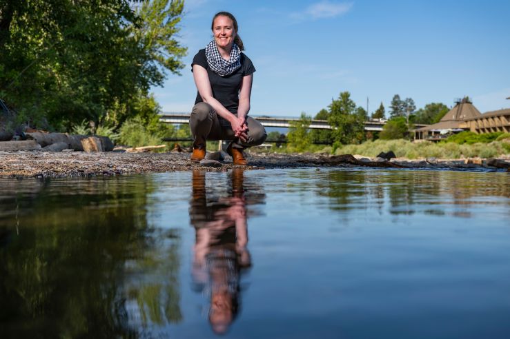 Woman kneeling by Clark Fork River