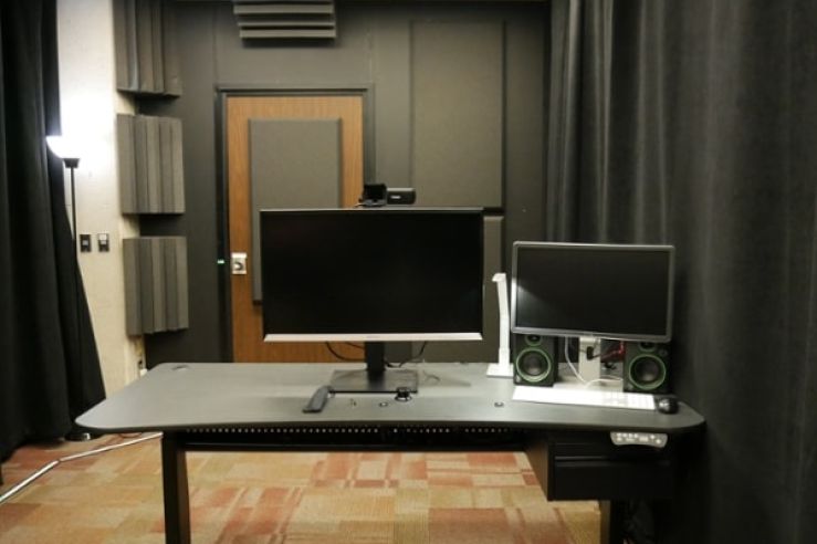 Two computer monitors on a desk in the lightboard studio